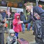Veteran Joe Leister shakes hands with Holly Eusterman, 8, with her brother, Mikey, 6, and mom, Jennifer Eusterman, watching the parade on Saturday. RACHEL CIAMPI, Auburn Reporter
