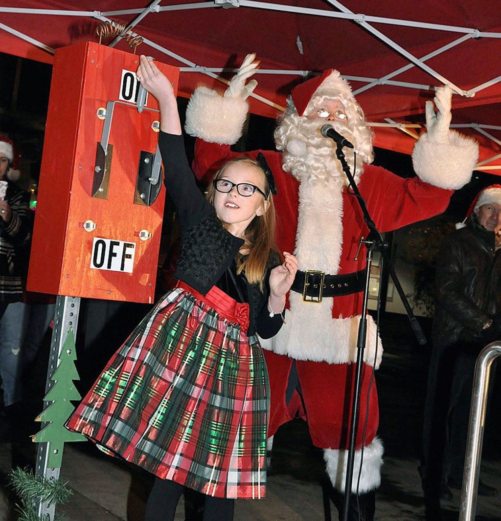 Santa Claus has Grace Orr turn the switch to light the Christmas tree in the City Hall Plaza. RACHEL CIAMPI, Reporter