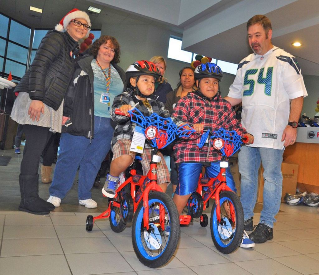 Manager George Hall have Alfredo Susano-Vargas, 5, and Heiser Martinez-Vargas, 10, choose bikes. RACHEL CIAMPI, Reporter