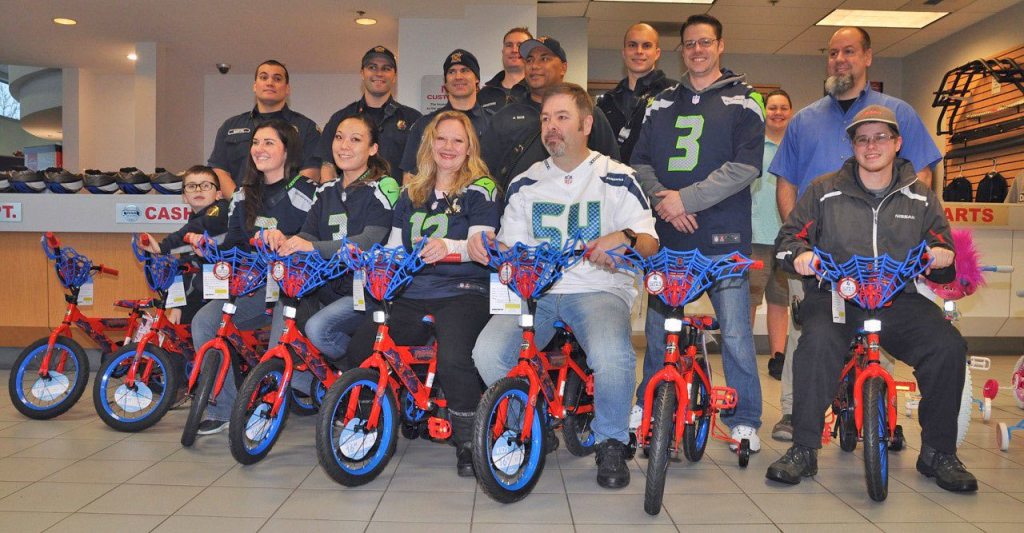 From right, on Spider-Man bikes: Marshall Willard, Manager George Hall, Leia Duckworth, Tammy Takayesu, and Andrea Hanson with her son Xander, 6. From right middle: Mike Carter (blue shirt), Arin Gardner (No. 3 Seahawks shirt) and in back, Coyote Carter (light blue shirt). Joining them are VRFA firefighters. RACHEL CIAMPI, Reporter