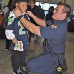 Valley Regional Fire Authority firefighter Aaron Martin has Joseph Robertson, 7, try on a bike helmet for size at Rairdon&rsquo;s Nissan of Auburn last Saturday. RACHEL CIAMPI, Auburn Reporter