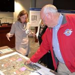 Chelsea Levy, government and community relations manager for Sound Transit, left, and former Auburn City Councilman Wayne Osborne examine a map displaying a range of possible sites for the agency&rsquo;s second transit parking garage in Auburn, during a recent community forum on the project at Auburn City Hall. REPORTER PHOTO, Robert Whale