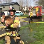 VRFA Firefighter Terry Robinson carries a dog rescued from an Algona house fire Tuesday. Capt. Norm Golden and firefighters Aaron Walker and Stewart Alway helped rescue the dog from the fire. There were no injuries. COURTESY PHOTO, VRFA