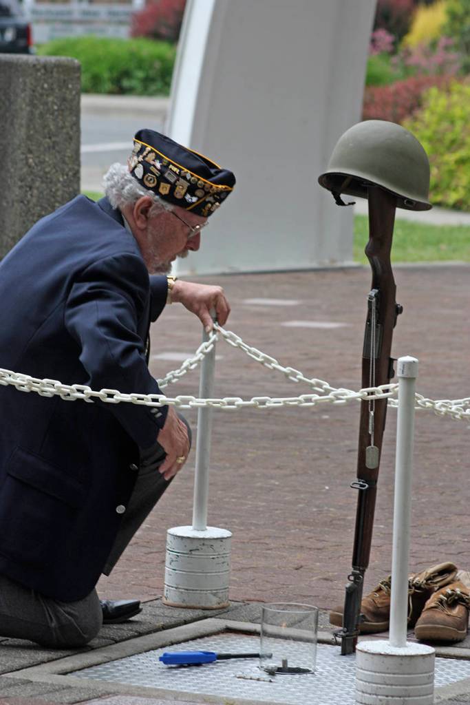 Tom Valencour, of American Legion Auburn Post 78, lights the Memorial Flame. MARK KLAAS, Auburn Reporter