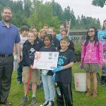 Allstate representative Michael McKee presents Ilalko Elementary students with a $250 WE Volunteer Now grant to put toward their beautification project at the school Tuesday. COURTESY PHOTO