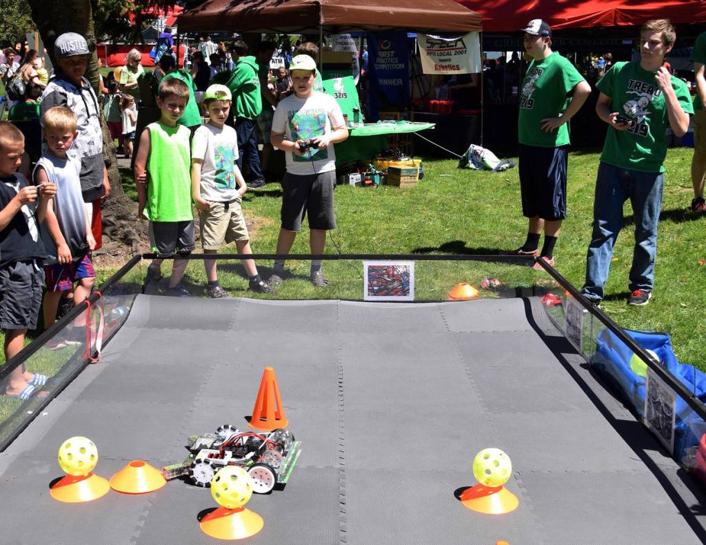 Garrett Parish and Jack Gray from Auburn High School robotics have kids try out their machines. RACHEL CIAMPI, Auburn Reporter
