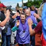 Cancer survivors exchange high-fives with supporters during the recent Auburn Relay for Life event at Memorial Stadium. COURTESY PHOTO