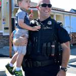 Algona Police Officer Anthony D&rsquo;Angelo and his son, Nolan, 3, take in the parade. RACHEL CIAMPI, Auburn Reporter