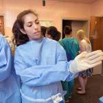 Genevieve Tipton, of Auburn, puts on her gown and gloves at Nurse Camp last week. COURTESY PHOTO, Patrick Hagerty