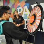 Aaron Orozco, of Renton, spins the wheel to win a gift card to the Green River College bookstore. Inspirus Credit Union handed out $10, $25 and $50 gift cards to students on the college&rsquo;s main campus in Auburn for the first day of the fall quarter on Monday. HEIDI SANDERS, Kent Reporter