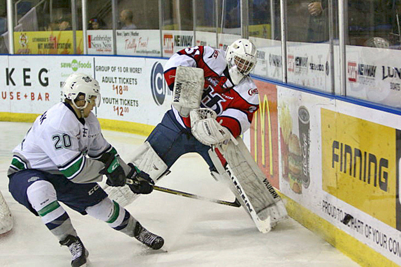 The Thunderbirds&rsquo; Zack Andrusiak applies pressure as Hurricanes goalie Reece Klassen clears the puck during WHL play Sunday in Lethbridge, Alberta, Canada. Andrusiak had a hat trick in Seattle&rsquo;s 7-4 win. COURTESY PHOTO, Cindy Adachi