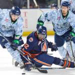 The Thunderbirds Matthew Wedman, left, and Blake Bargar battle the Blazers Jermaine Loewen for the puck during WHL play Saturday night. COURTESY PHOTO, Brian Liesse, T-Birds