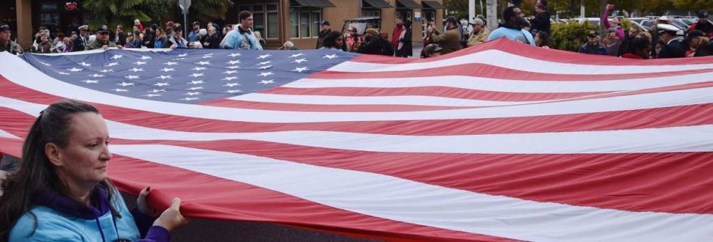 A large flag is unfurled during the parade march. RACHEL CIAMPI, Auburn Reporter
