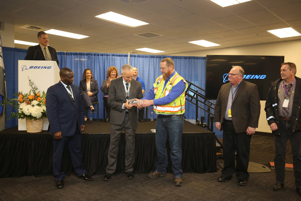 Marc Schwartz, the Seattle superintendent of Lease Crutcher Lewis, which built the new Workforce Readiness Center, hands large-sized 3D-printed keys to Boeing tenants in a ceremony at the grand opening of the building on Monday. From left: Jack Meehan, leader of the Boeing Auburn site (standing at podium); Charles Fisher (blue suit), senior leader of Leadership, Learning and Organizational Capability; Tom Kelleher, Workforce Readiness Center leader; Schwartz; Matt Hale, co-executive director of IAM/Boeing Joint Programs; and Brett Coty, co-executive director of IAM/Boeing Joint Programs. COURTESY PHOTO, Boeing
