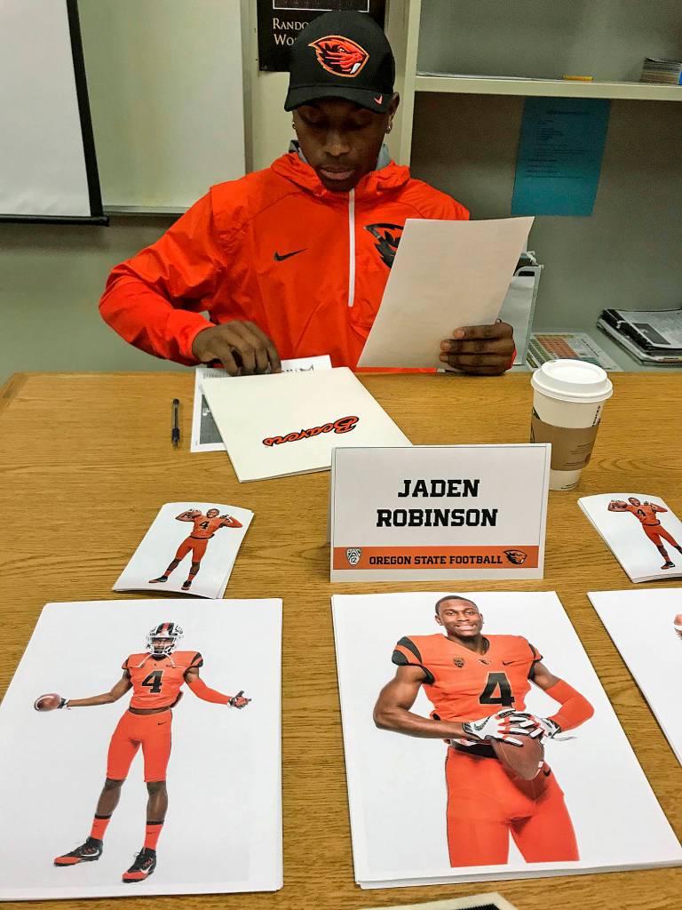 Auburn Riversides Jaden Robinson goes over his paperwork before officially signing with Oregon State University. The Beavers want Robinson to play cornerback. MARK KLAAS, Auburn Reporter