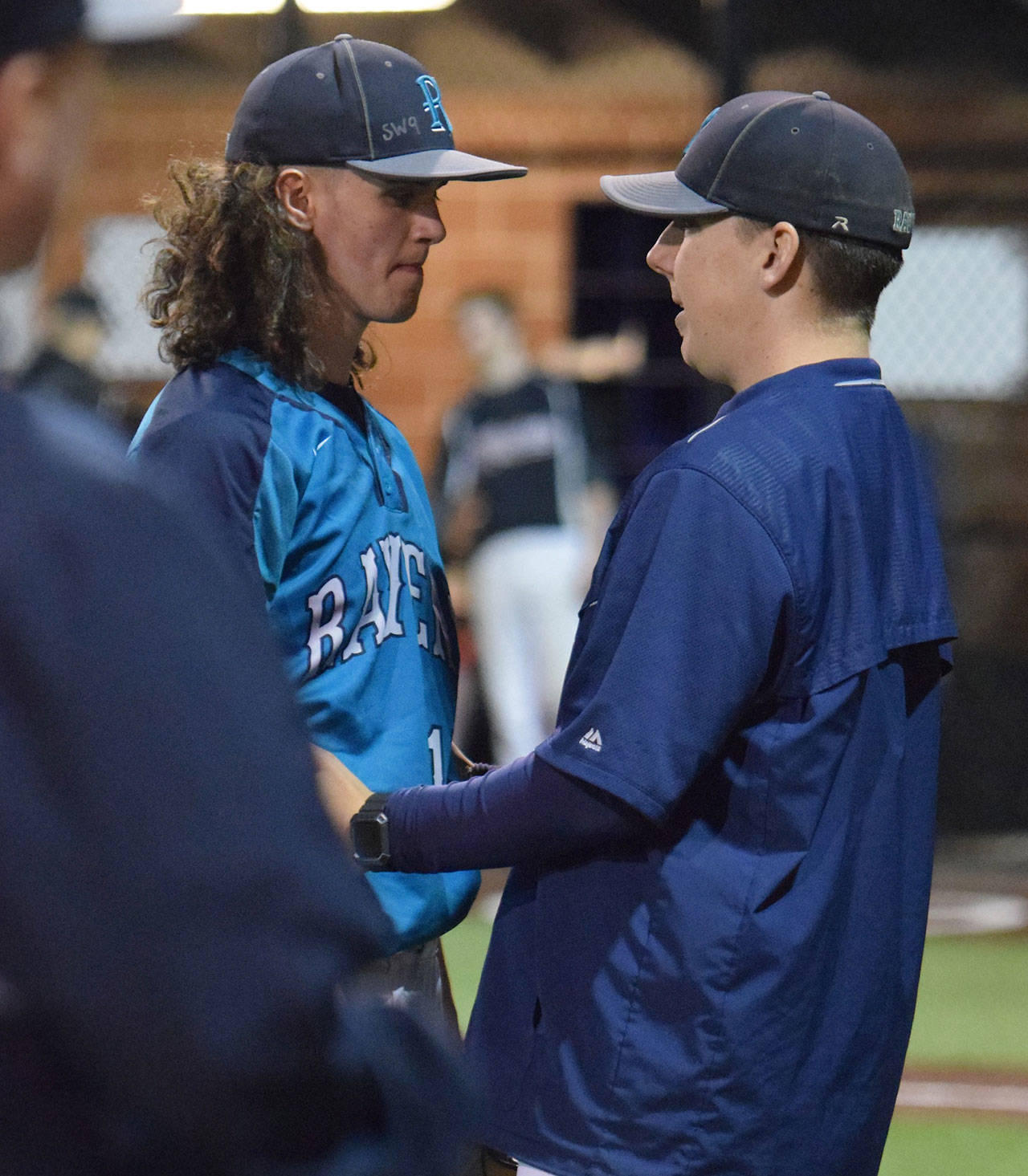Auburn Riverside coach Marcus Evans talks to pitcher Dylan Ostler during the Ravens 3-2 loss to Kentlake on Monday night. RACHEL CIAMPI, Auburn Reporter