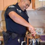 Officer Sedillo stirs chili during the cook-off. RACHEL CIAMPI, Auburn Reporter