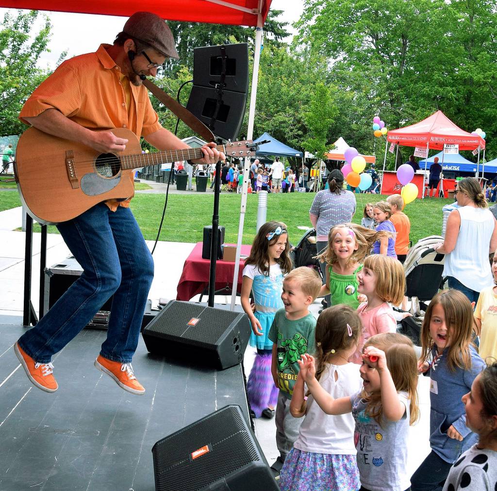 Eric Ode performs a song as kids dance to the beat.