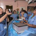 Tiffany Nguyen, 17, left, of Kent, laughs with Tiffany Jinks, 16, of Tacoma, as she attempts to grab candy with an alligator clamp while learning about laparoscopic surgery last week during Nurse Camp at Tacoma General Hospital. Photo by PATRICK HAGERTY