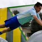 Brian Silva, above, jumps on the inflatable in Les Gove Park at the AuburnFest. Right, Joycelyn, 10, and Lupe Gutierrez, 7, sail down the slide in the rain at the park.