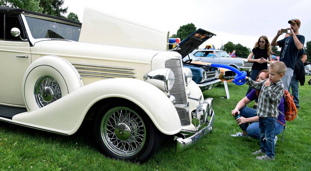 Kolby Benson, 4, and his friend Ashley Lewis take in the classic makes at the car show. RACHEL CIAMPI, Auburn Reporter