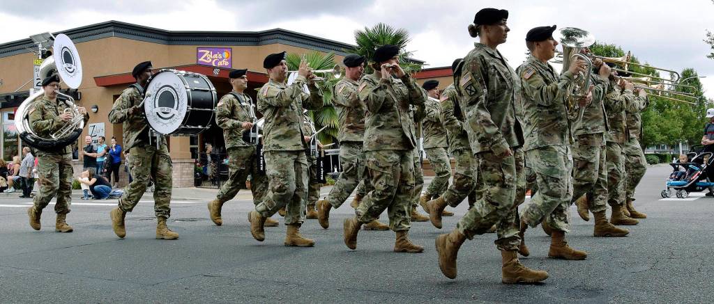 The Veteran Band marches in the parade. Right, Kolby Benson, 4, and his friend, Ashley Lewis, take in the classic makes at the car show.