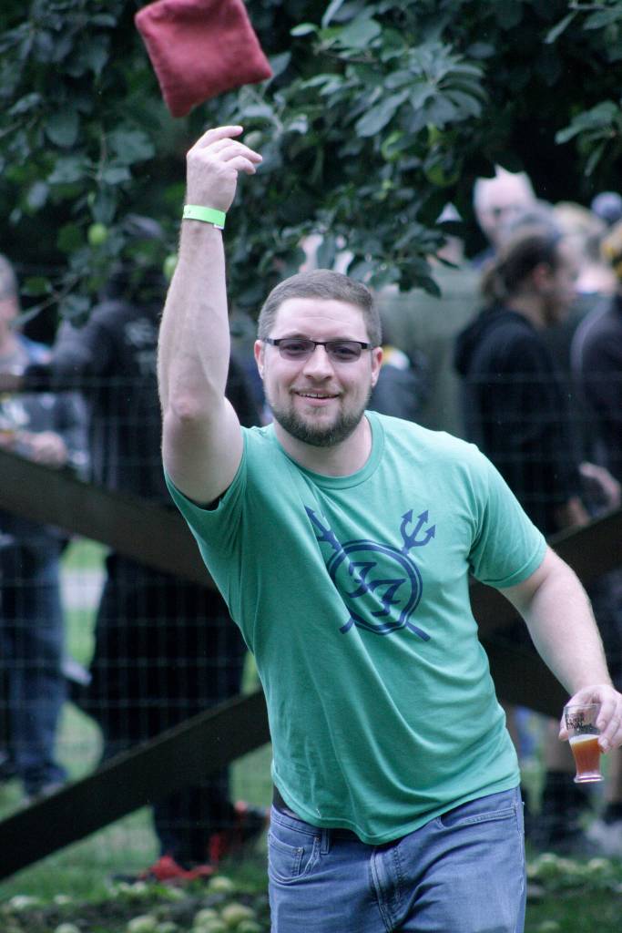 Aaron Woods tosses a bean bag in a lawn game at Mary Olson Farm. MARK KLAAS, Auburn Reporter