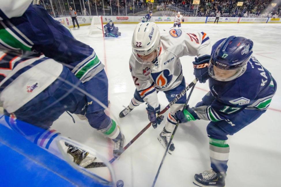 The Thunderbirds Jaxan Kaluski, right, battles the Blazers Martin Lang for the puck along the boards during WHL play Friday night. COURTESY PHOTO, Brian Liesse, T-Birds