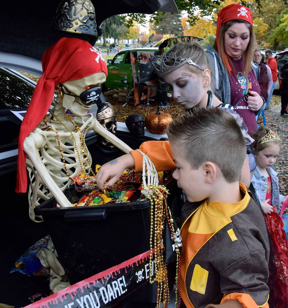 Krystal Sanders as a pirate has Shaylee Bonzan, 9, and Landon Gregory, 7, get candy from the treasure chest. RACHEL CIAMPI, Auburn Reporter