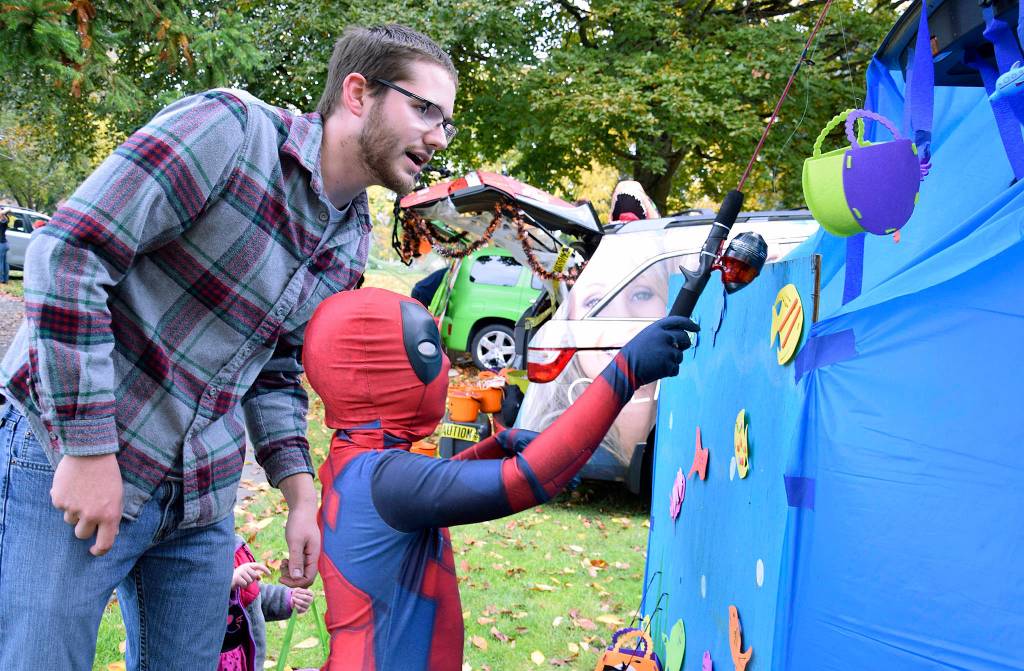 Josiah McCracken from River Foursquare Church has Mattheo Diaz, 6, fish for candy.