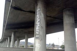 Graffiti decorates the foundation of the State Route 18 overpass in Auburn. City officials are looking at ways to confront a chronic problem. FILE PHOTO
