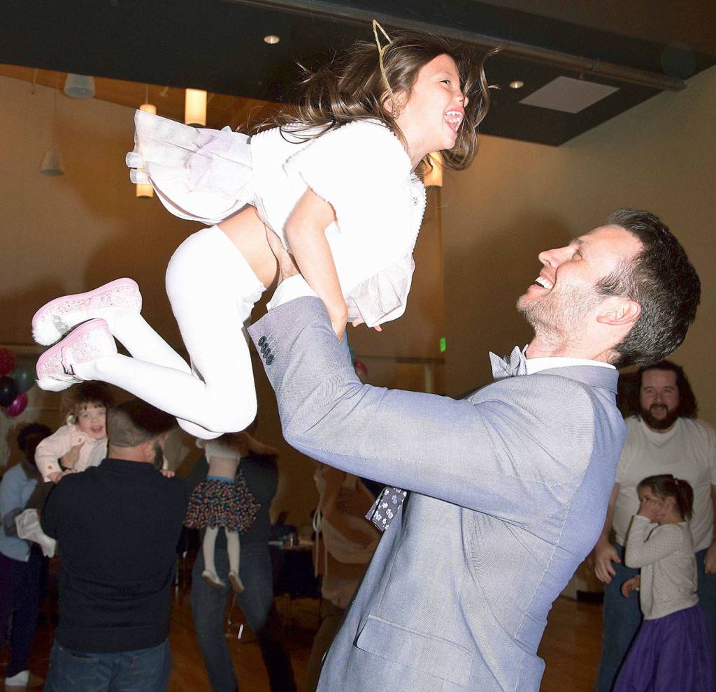 James Dawson lifts his daughter Violet, 5, at the dance. RACHEL CIAMPI, Auburn Reporter