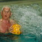 Early Bird Carl Linden shoots from the baseline as the defense ruffles the waters during recent aquatic basketball play at the Auburn Valley YMCA. Linden, who turned 80 on March 13, has been a regular at the Y since 1975. MARK KLAAS, Auburn Reporter