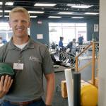 Abraham Ward, manager of Olympic Sport and Spine, hefts one of the balls that the clinic uses to rehabilitate patients. ROBERT WHALE, Auburn Reporter