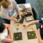 Aleah Adams, of Federal Way-based Fantasium Comics and Games, shares her game, Fireworks, to players during Teen Game Night on Thursday, June 6 at the Auburn Library. MARK KLAAS, Auburn Reporter