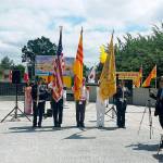 Flags of the two nations that fought side-by-side in the Vietnam War look down upon the dedication of the joint American-Vietnamese Memorial at Les Gove Park last year. ROBERT WHALE, Auburn Reporter