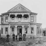 The family of Aaron, Sr. and Sarah Neely pose in front of their new Green River Valley home, east of Auburn, mid-1890s. The young boy, third from left, appears to be Aaron Neely, Jr., father of Howard Elliot Neely (see 2010 photo); Sarah Graham Neely, wife of Aaron, Sr., is on the far right. COURTESY, Neely Mansion Association.