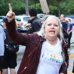 Jen Carter, vice chair of the King County Democrats, leads supports in chants to drown out a street preacher protesting the reading event. Aaron Kunkler/staff photo