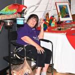 Parrot Expo Board member Jackie Cotrell has Nika Covaljiu, 5, look at her parrots Domino and Madison. RACHEL CIAMPI, Auburn Reporter