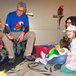 Russ Campbell tells a parrot story to Esmeralda Salamone and her daughters Amalia, 7, and Artaea, 2, with the parrot Molly watching. RACHEL CIAMPI, Auburn Reporter