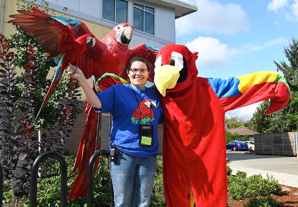 The Parrot Lady, Debbie Goodrich, and her parrot Oly, with the parrot mascot Tui. RACHEL CIAMPI, Auburn Reporter