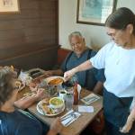 Lorie Mortensen shares a laugh with Stanley Moses, one of her original customers, wife Mary Ann, and their granddaughter at the Starting Gate restaurant. ROBERT WHALE, Auburn Reporter