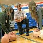Valley Regional Fire Authority Deputy Chief Dave Larberg gives instruction to Auburn Mountainview High School students Ashley Tran, left, and Makena Madsen during their visit Nov. 27. MARK KLAAS, Auburn Reporter