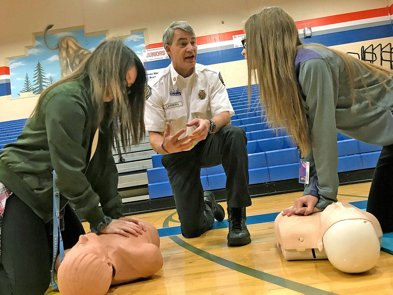 Valley Regional Fire Authority Deputy Chief Dave Larberg gives instruction to Auburn Mountainview High School students Ashley Tran, left, and Makena Madsen during their visit Nov. 27. MARK KLAAS, Auburn Reporter