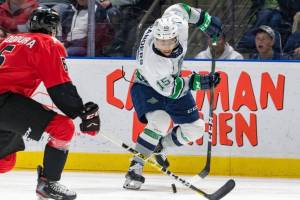 The Thunderbirds Mekai Sanders maneuvers the puck up the ice as the Cougars Majid Kaddoura defends during WHL play Sunday at the accesso ShoWare Center. COURTESY PHOTO, Brian Liesse, T-Birds