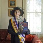 Wearing suffragist attire, Neely Mansion Association board member Hilda Meryhew displays Womens Votes, Womens Voices, the book that author Shanna Stevenson will be talking about at the March 21 Bookmarks & Landmarks program at Neely Mansion. COURTESY PHOTO