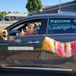 A Lakeland Hills Elementary teacher riding in the districts car and bus parade last week signals her eagerness to welcome students to school on opening day Sept. 9. Courtesy photo