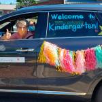 A Lakeland Hills Elementary teacher riding in the districts car and bus parade last week signals her eagerness to welcome students to school on opening day Sept. 9. Courtesy photo