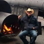 Jack Timmons pauses for a smoke next to his two giant smokers at Jacks BBQ, which he opened last week on West Valley Highway in Algona.