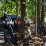 Homelessness Outreach Program Coordinator Kent Hay delivering mail to a resident of the camp on Friday, Aug. 27, 2021. Photo by Henry Stewart-Wood/Sound Publishing
